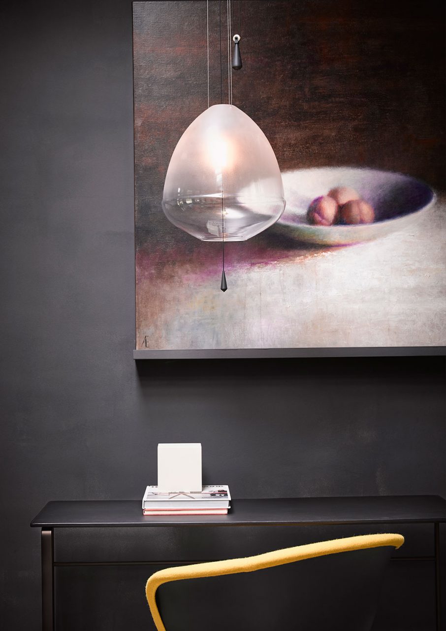 Clear Limpid light M by Studio VANTOT above a black desk.