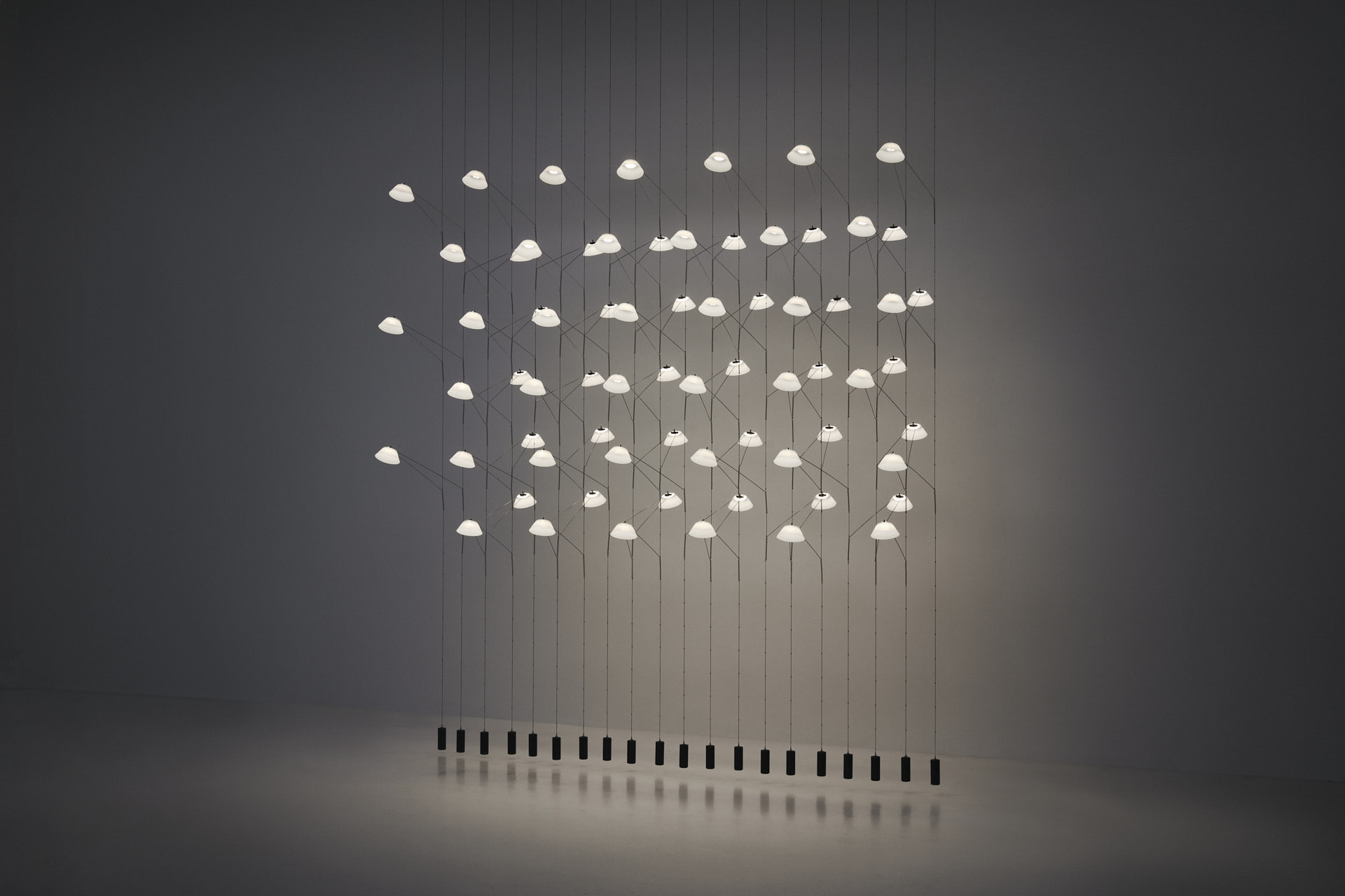 Liiu arranged in a wall like configuration, suspended from to ceiling reaching the floor.