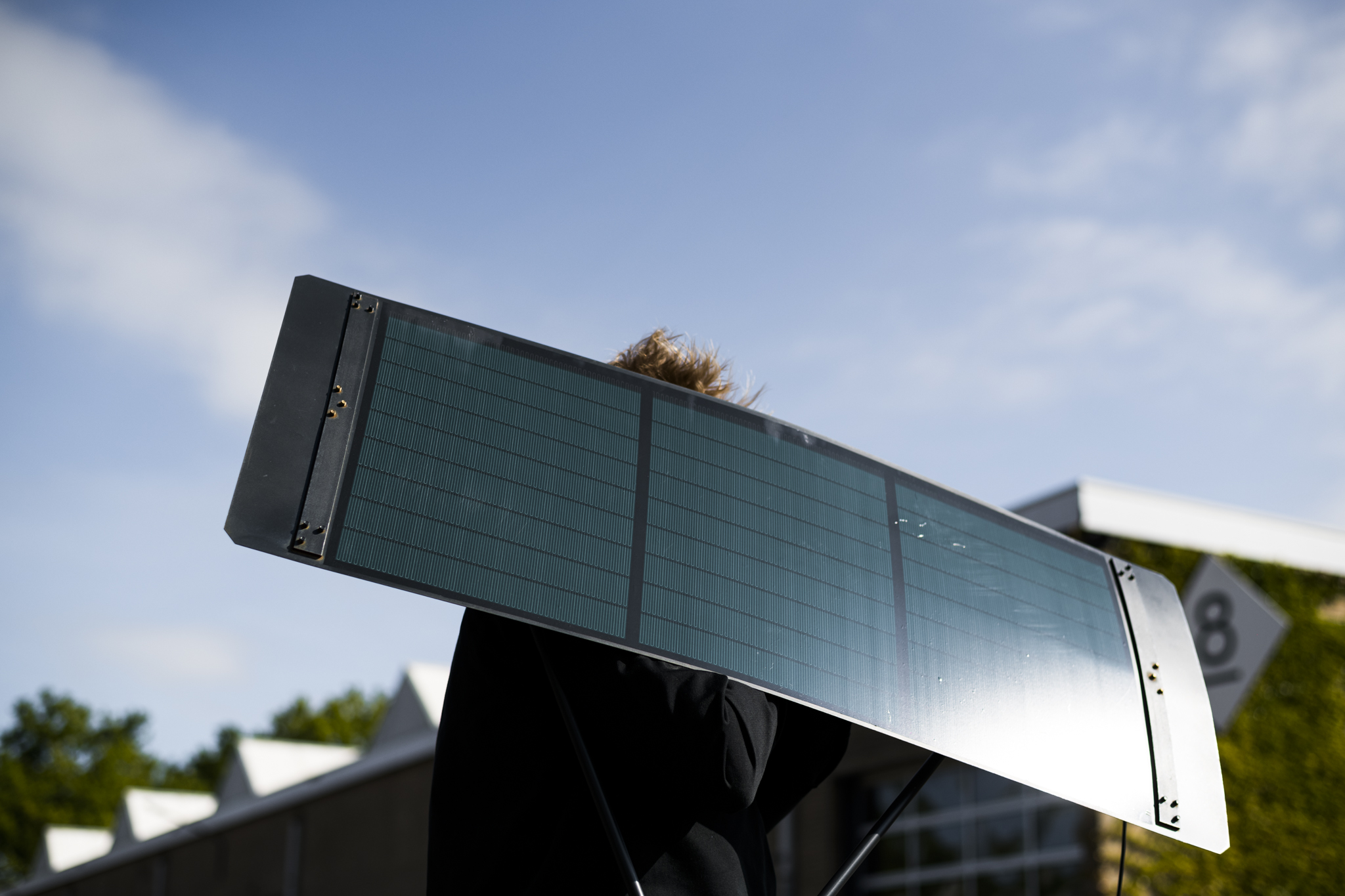 Sam van Gurp carrying a Pendulum product showing it's solar panel. 